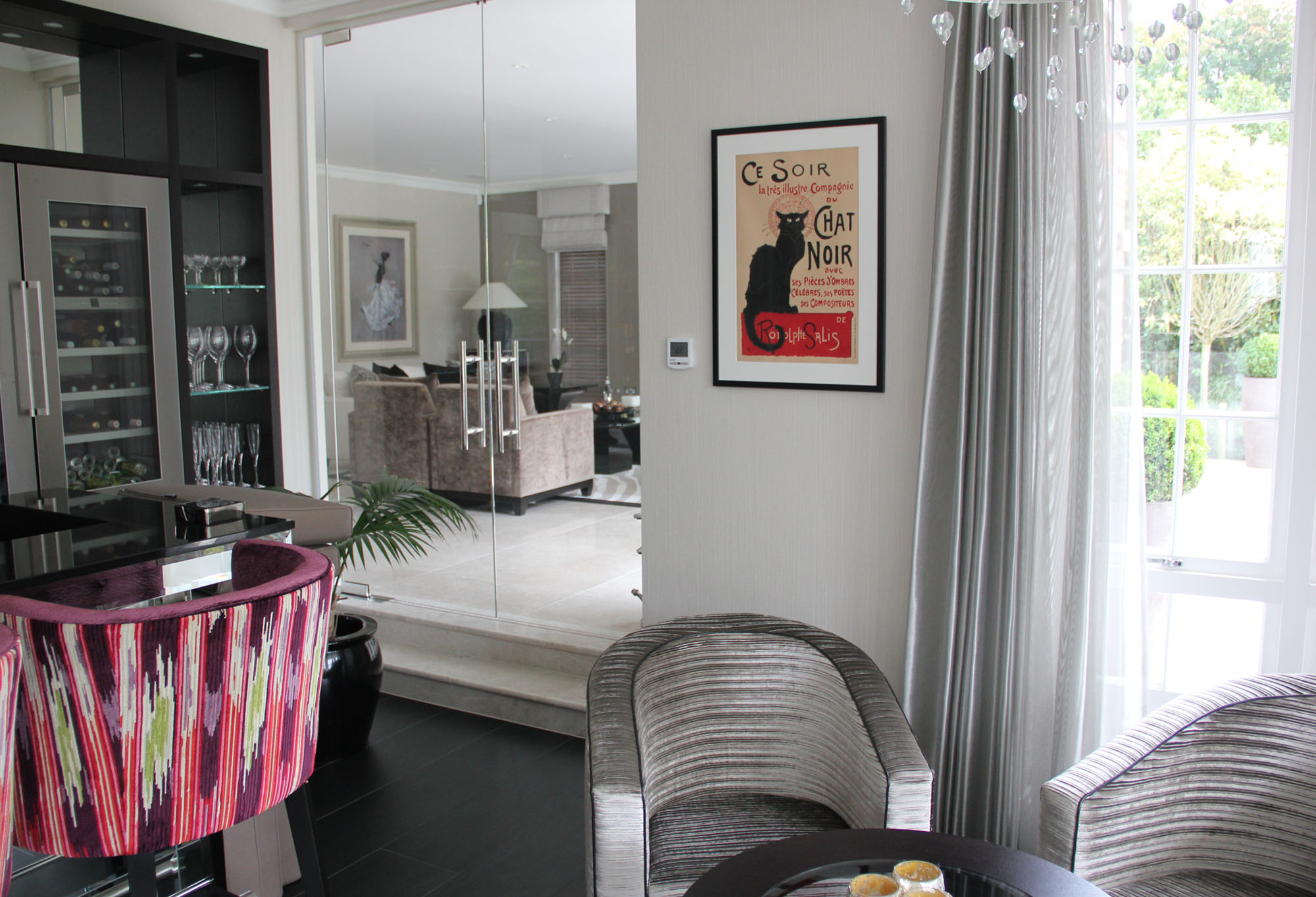 Sleek, Art Deco dining area with classic black cat poster; red, purple, black, grey